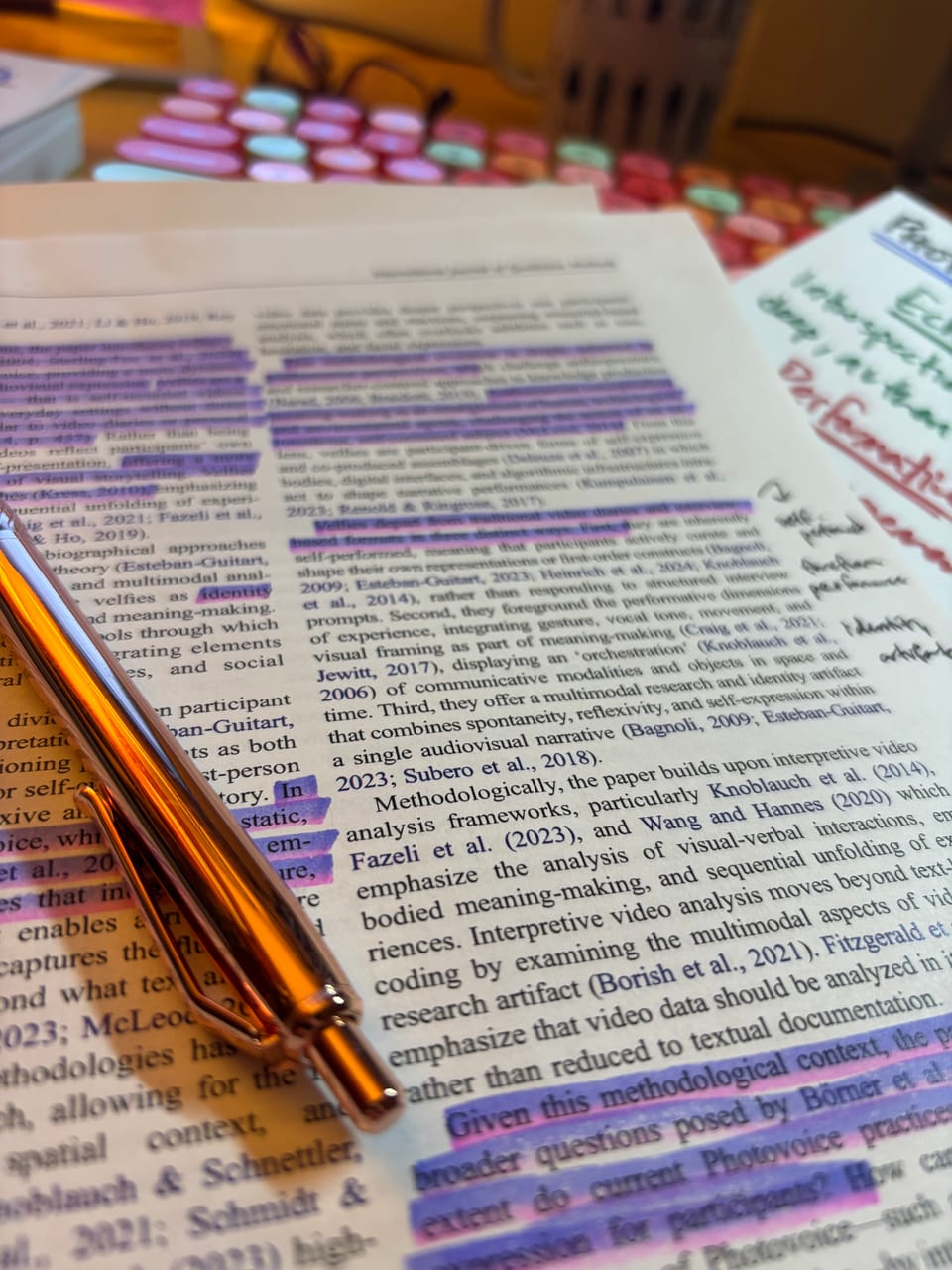 pen on top of a journal article with highlights and marginalia