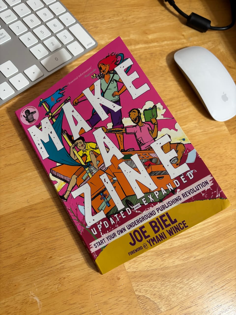 colorful book on a wooden table with the title Make a Zine